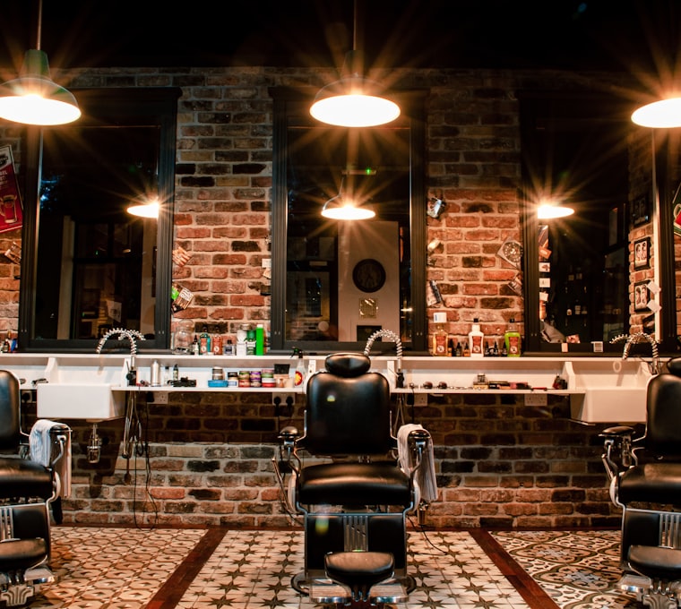 A leather barber chair against a brick wall