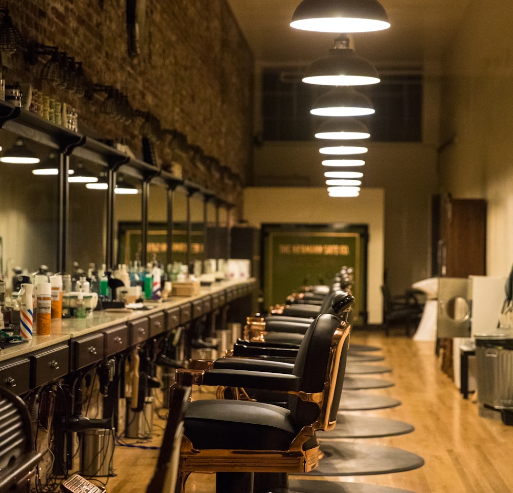 The shop interior, lit warm, chairs along the mirrored wall